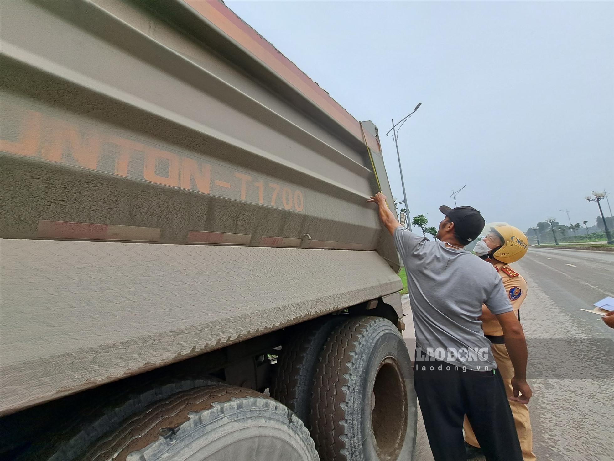 Lực lượng chức năng tiến hành đo đạc, kiểm tra thực tế kích thước thùng xe sơ mi rơ mooc vi phạm về quá khổ, quá tải.