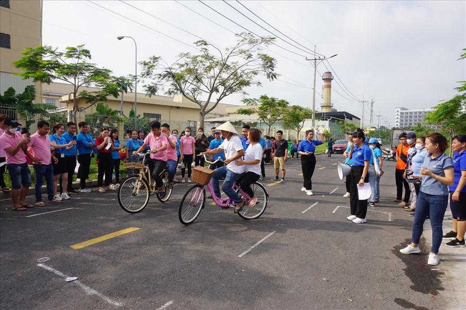 Công nhân lao động tham gia trò chơi chạy xe đạp chậm đôi.