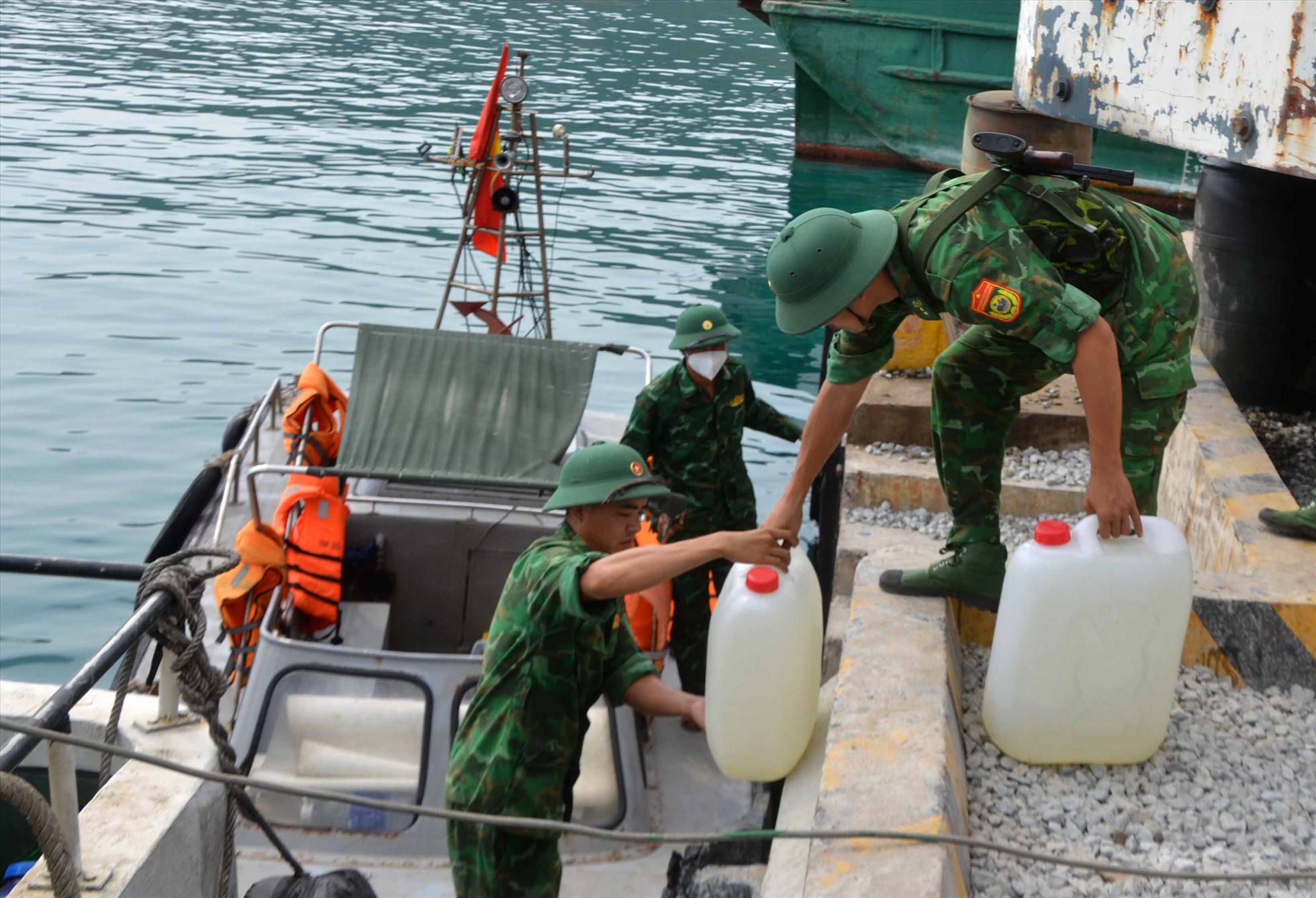 Sau đó tiếp tục chở từng thùng nước ngọt và cả đất để chăm sóc đảm bảo cây phát triển trên nền đảo đá. Ảnh: Lục Tùng