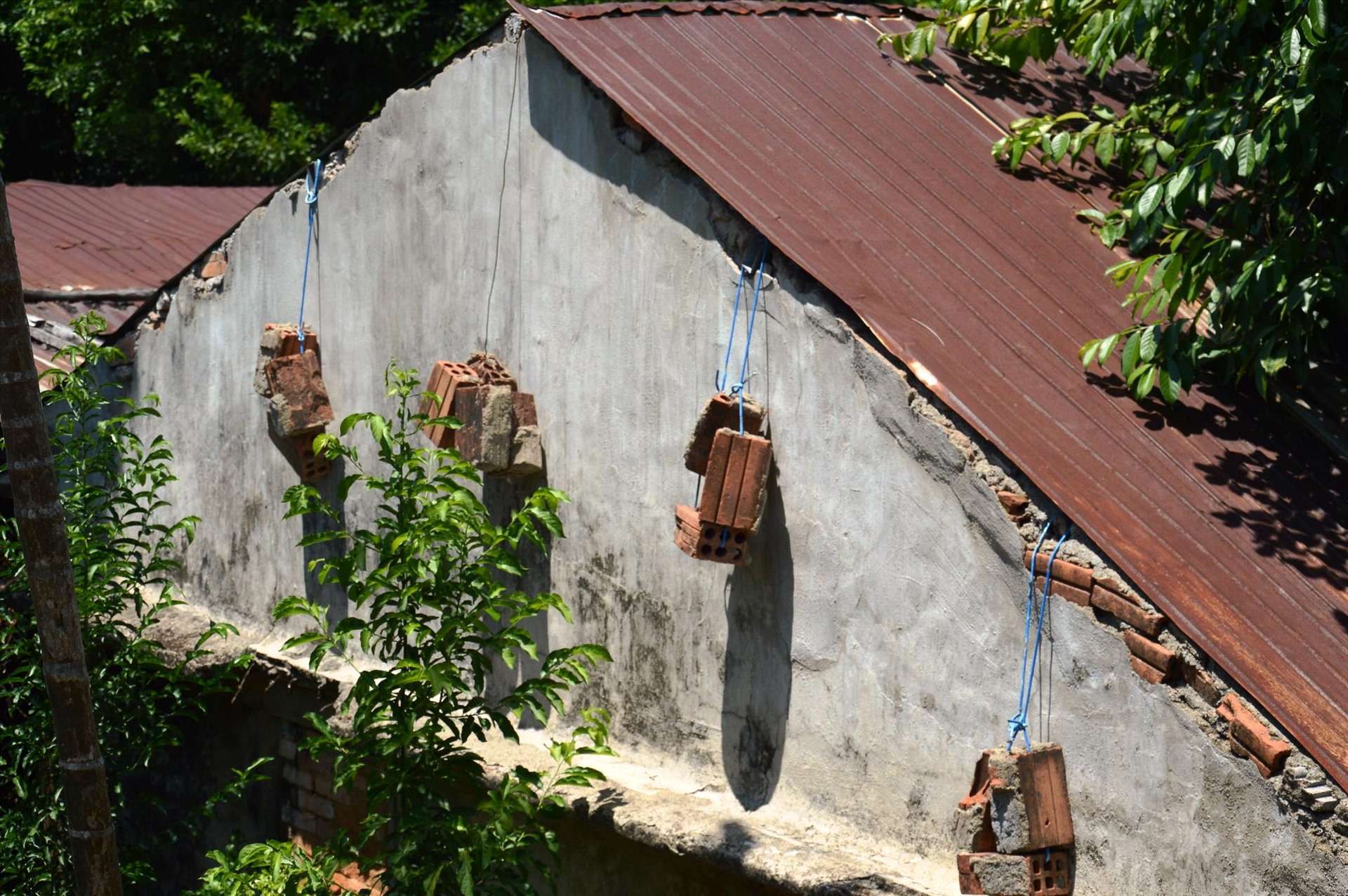 Nhà cửa xuống cấp nghiêm trọng, người dân dùng gạch để chằn chống phần mái. Vào mùa mưa bão dân không dám ở trong nhà vì lo nhà sập. Ảnh: Ngọc Viên