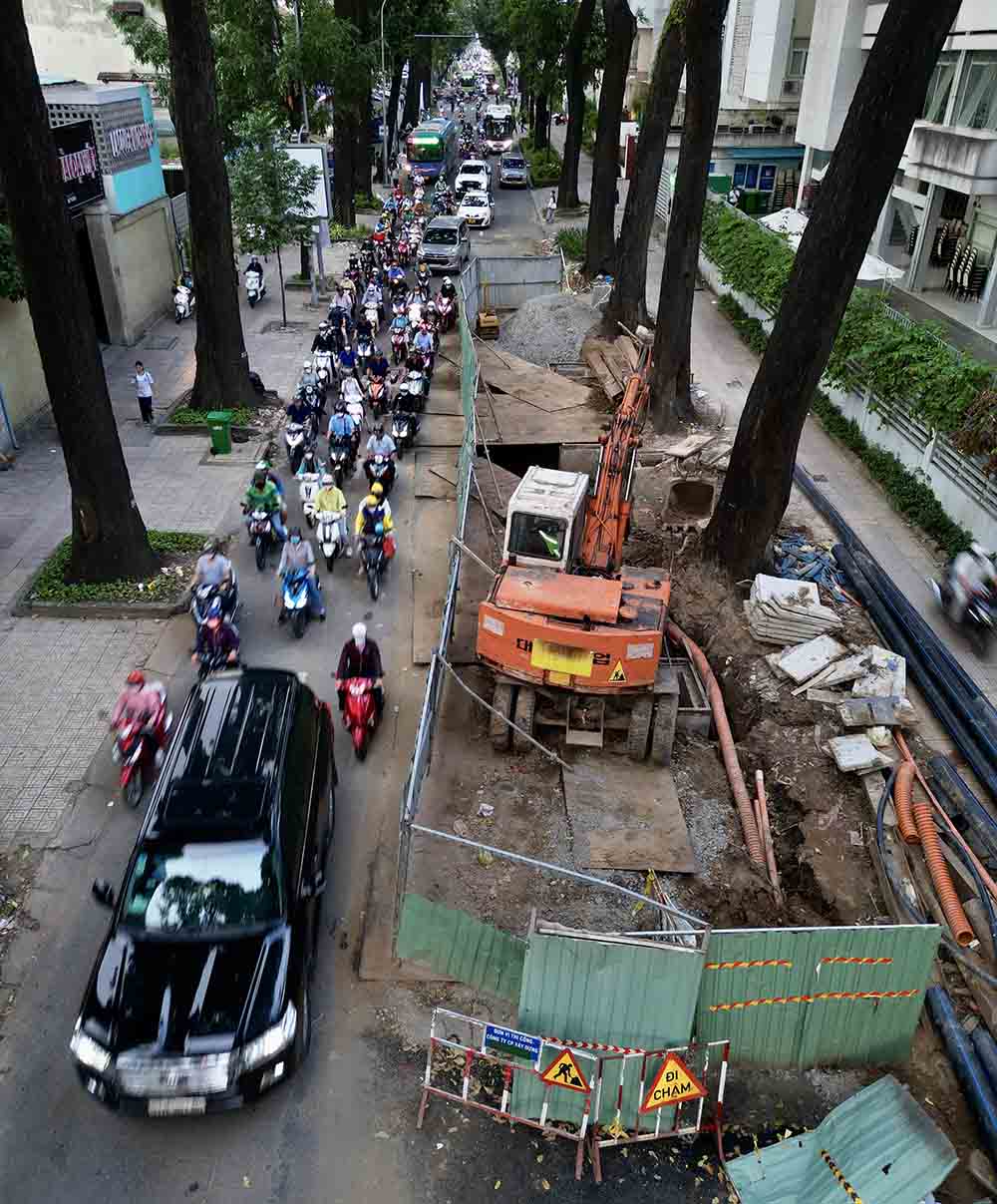 Dãy hàng rào bằng tôn cao khoảng 2 m, chiếm hơn 1/2 bề rộng lòng đường. Phần đường còn lại khoảng 3 m, vừa đủ một ôtô lớn chạy qua khiến các xe phía sau phải xếp hàng dài, chen nhau bóp còi inh ỏi.