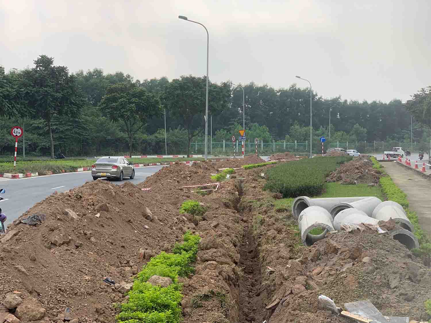 Nửa còn lại tại dải phân cách đang trong quá trình nhổ bỏ cây xanh để xén, công trình vẫn đang ngổn ngang. Ảnh: Nhật Minh