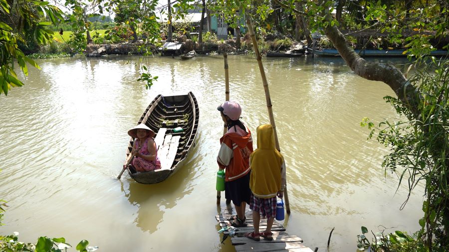 Không có đường đi người dân bắt buộc phải dùng ghe, xuồng để qua kênh. Ảnh: Tạ Quang