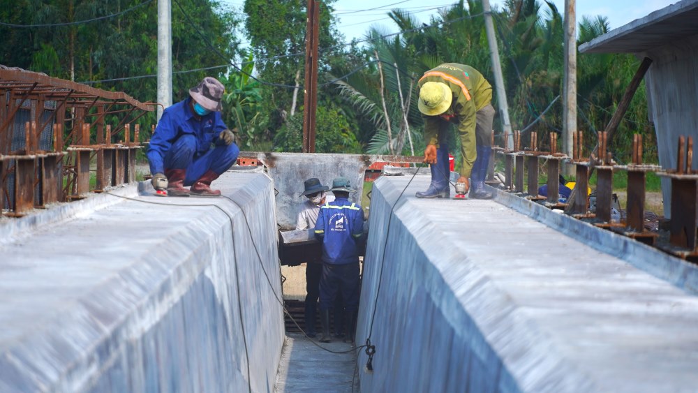 Công nhân thi công dầm để làm cầu. Ảnh: Tạ Quang