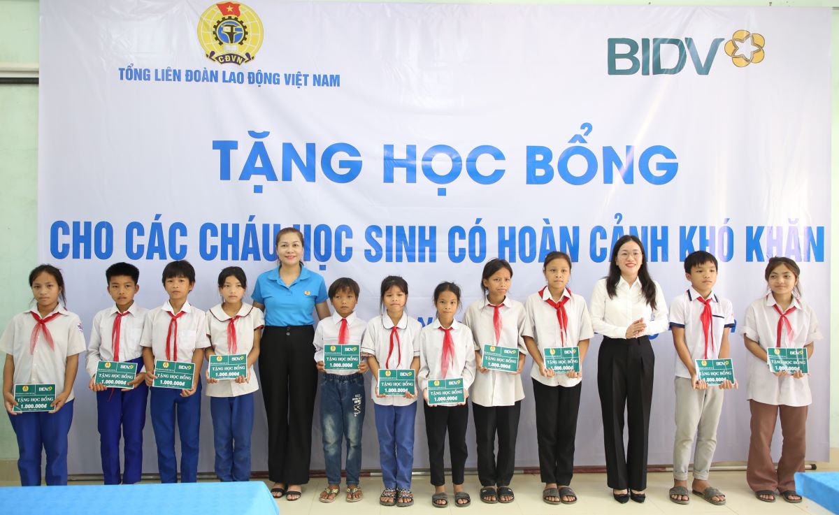 Tặng học bổng cho các em học sinh. Ảnh: Hưng Thơ.