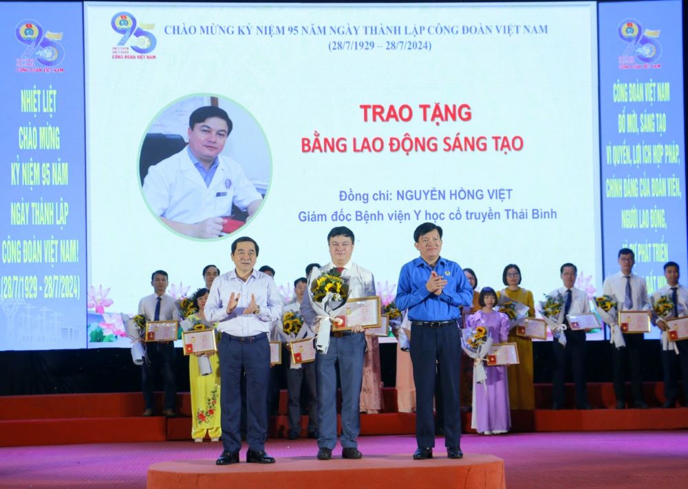 Ông Nguyễn Xuân Hùng - Phó Chủ tịch Tổng Liên đoàn Lao động Việt Nam và ông Nguyễn Tiến Thành - Phó Bí thư Thường trực Tỉnh ủy Thái Bình trao Bằng Lao động sáng tạo của Tổng Liên đoàn Lao động Việt Nam, tặng hoa chúc mừng