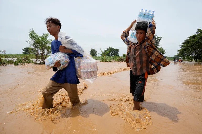 Người dân địa phương lội qua một con đường bị ngập lụt ở Thủ đô Naypyidaw