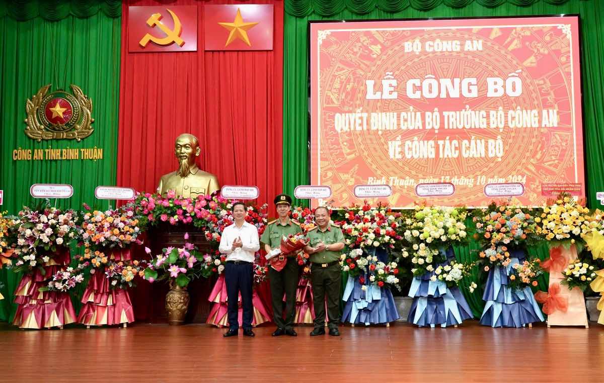 Đại tá Lê Quang Nhân, Giám đốc Công an tỉnh Bình Thuận và ông Đoàn Anh Dũng, Chủ tịch UBND tỉnh Bình Thuận trao hoa chúc mừng Đại tá Lê Thanh Hùng. Ảnh: Văn Hoàn