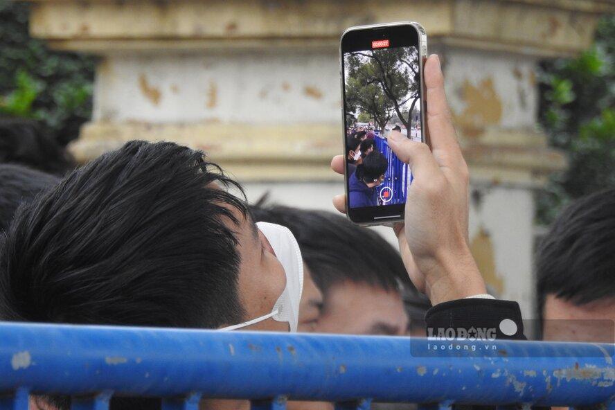Nhiều người xếp hàng đã quay lại những video, chụp những tấm ảnh “báo cáo” với người thân về “tiến độ” xếp hàng. Ảnh: Tô Công.
