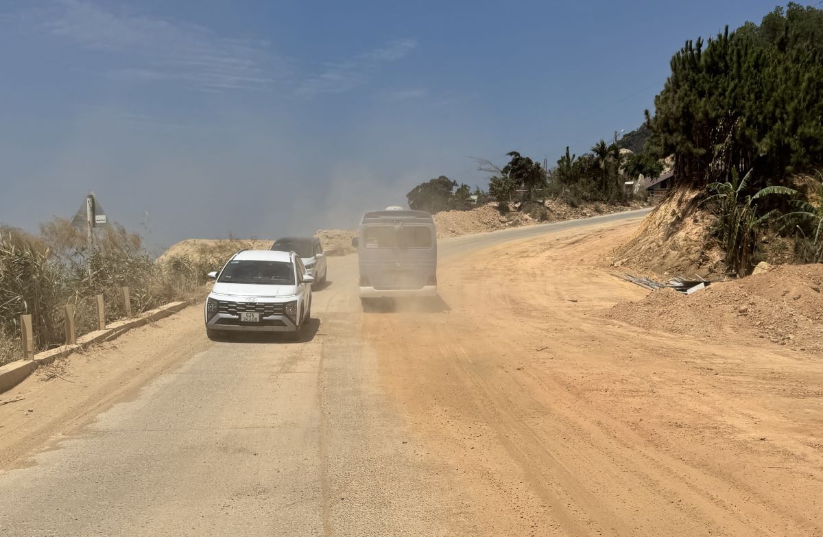 Các ô tô chạy qua mặt đường nền đất tung bụi mù mịt. Ảnh: Duy Tuấn