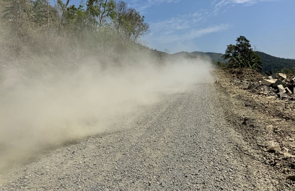 Bụi bay mịt mù khi có ô tô chạy qua. Ảnh: Duy Tuấn