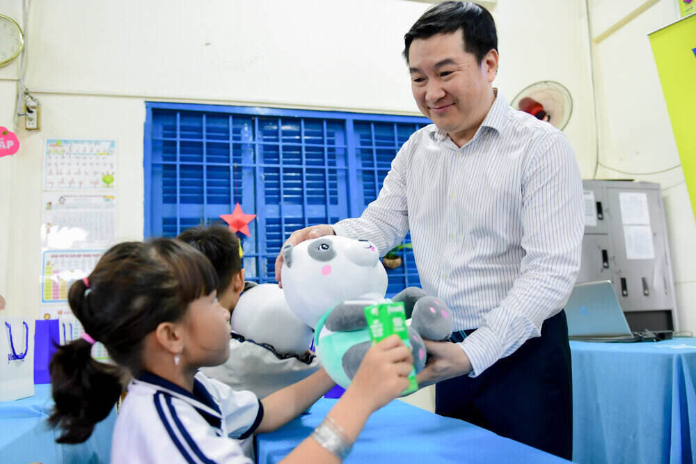 Các em học sinh đón nhận sữa, gấu bông và các món quà khác từ Vinamilk. Ảnh: Nam Anh