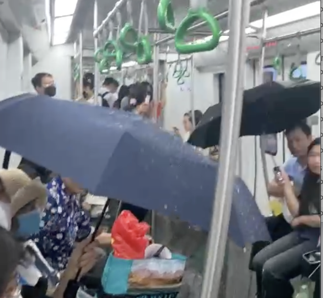 Hình ảnh người dân phải che ô tránh &quot;mưa&quot; trên tàu metro Cát Linh- Hà Đông vào chiều tối 19/5