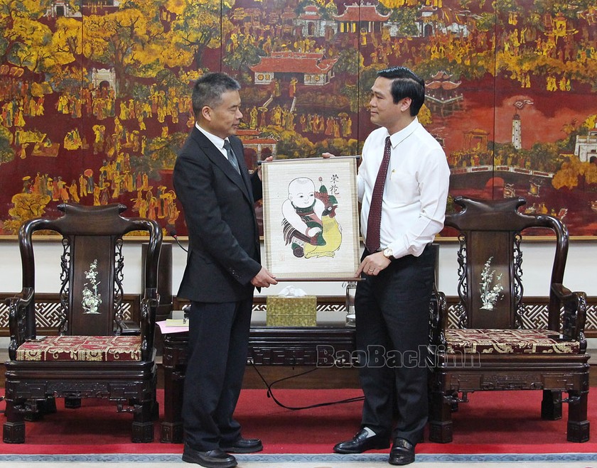 Phó Chủ tịch UBND tỉnh Lê Xuân Lợi (áo trắng) trao tặng Phó Chủ tịch Tổng Công hội tỉnh Chiết Giang Hu Haibiao bức tranh dân gian Đông Hồ. (Ảnh báo Bắc Ninh)