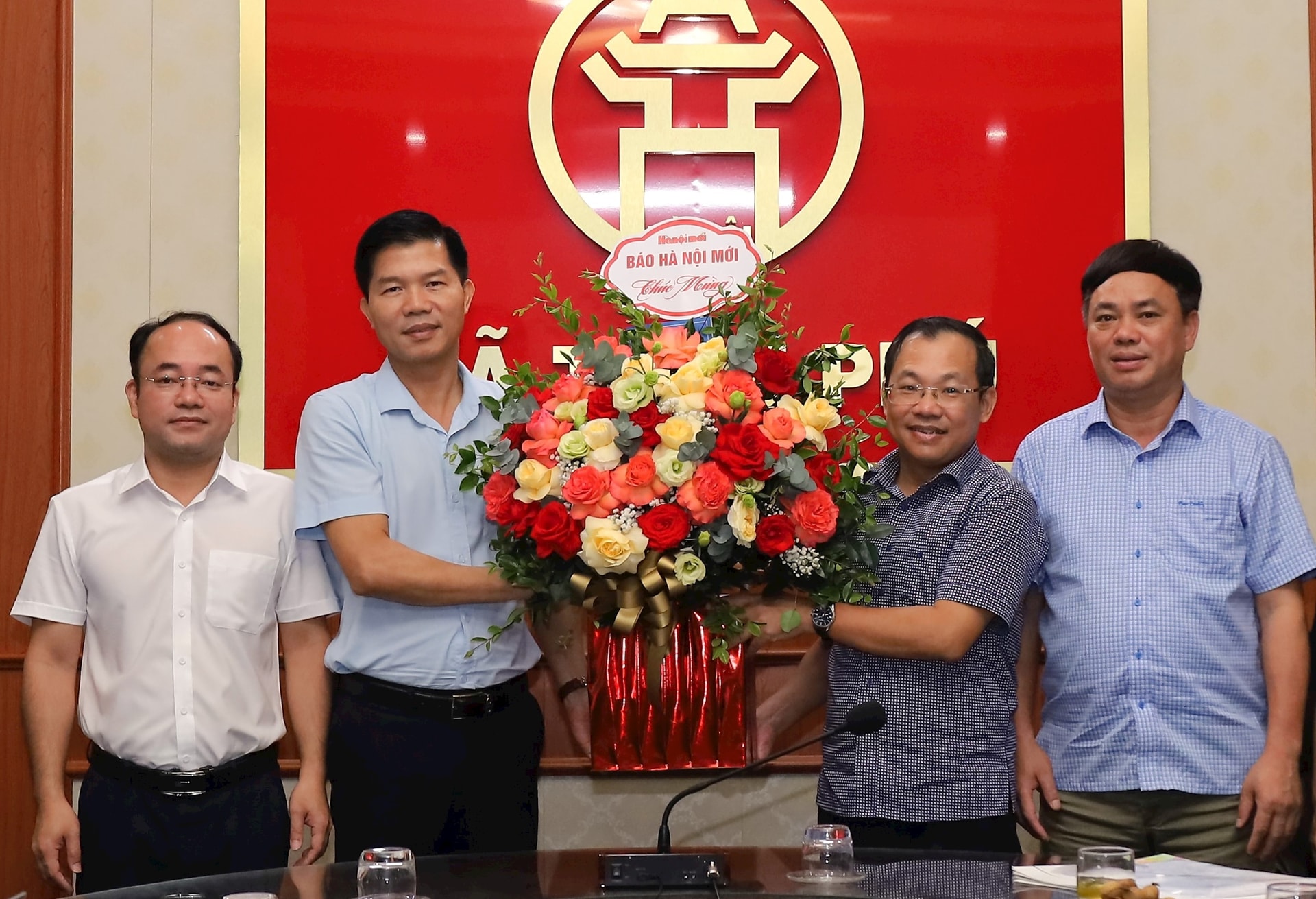 Đoàn công tác Báo Hànộimới tặng hoa chúc mừng đại diện lãnh đạo Đảng ủy, HĐND, UBND, MTTQ Việt Nam xã Trần Phú mới thành lập theo mô hình chính quyền địa phương hai cấp. Ảnh: Kim Nhuệ
