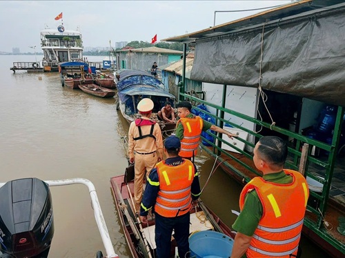 CSGT Đường thuỷ và chính quyền phường Hồng Hà tuyên truyền, nhắc nhở người dân chủ thuyền bè, nhà nổi về phòng chống thiên tai. Ảnh: Mạnh Đồng