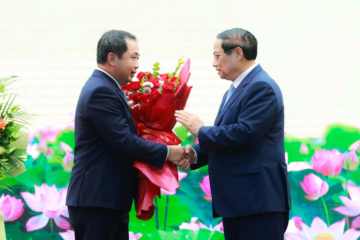 Thủ tướng Chính phủ Phạm Minh Chính tặng hoa chúc mừng quyền Bộ trưởng Bộ Nông nghiệp và Môi trường Trần Đức Thắng. Ảnh: Hải Nguyễn