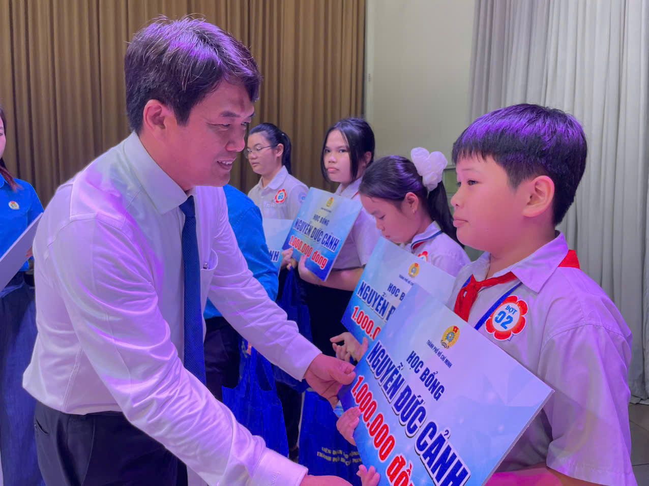 Ông Bùi Thanh Nhân - Chủ tịch LĐLĐ TPHCM trao học bổng cho học sinh. Ảnh: Đình Trọng