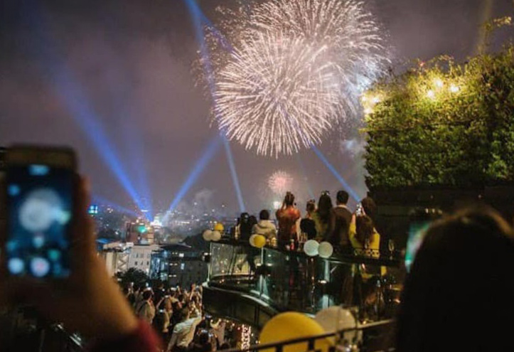 Khách xem pháo hoa tại một quán bar ở trung tâm phố cổ Hà Nội. Ảnh: Estrella Skybar