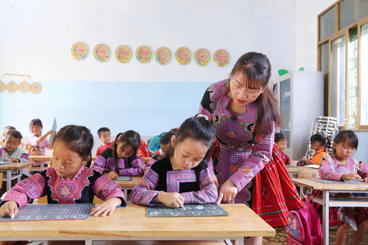 Cô Giàng Thị Sao, giáo viên môn Âm nhạc vừa dạy tiếng Việt, vừa tập viết cho các em học sinh vùng cao. Ảnh: Bình Khang