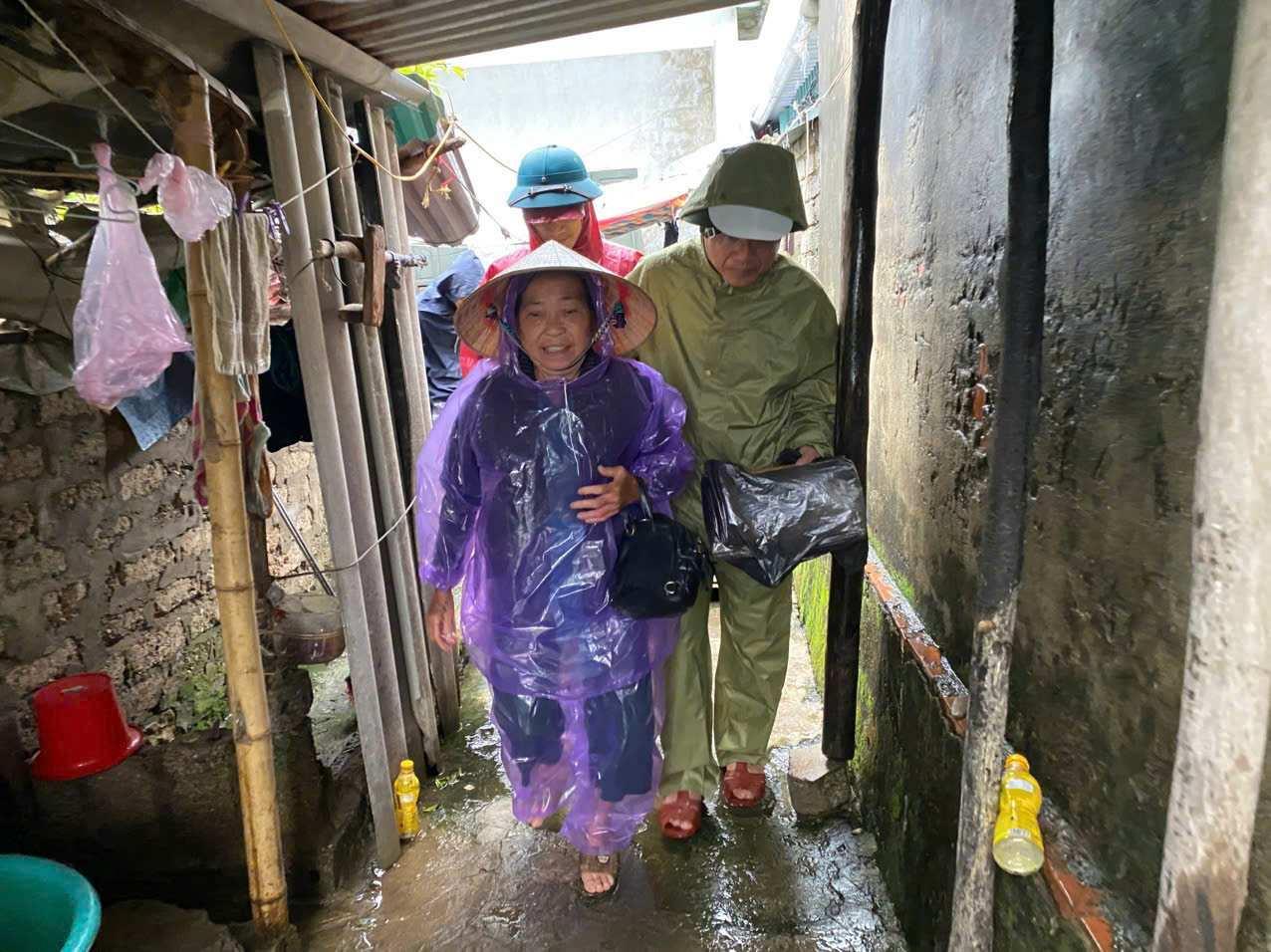 Lực lượng chức năng hỗ trợ người dân di dời đến điểm an toàn. Ảnh: Phạm Chung