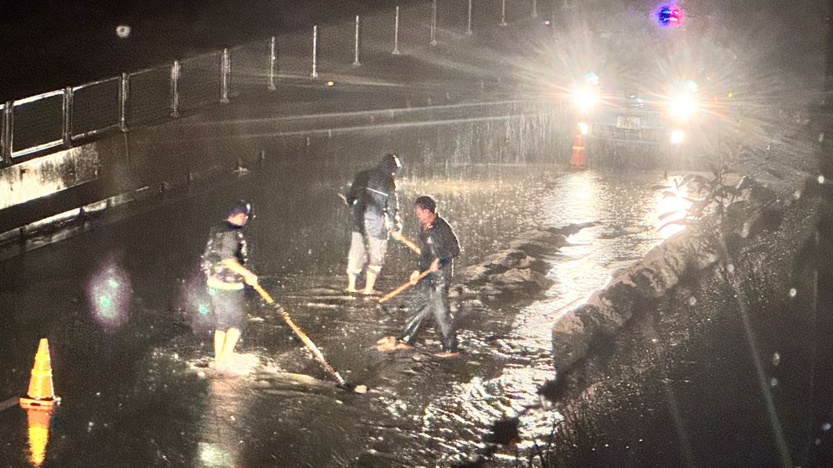 Đơn vị quản lý tuyến cao tốc khẩn trương cào dọn đất cát, nước mưa ứ đọng trên mặt đường giưuax đêm. Ảnh: Duy Tuấn