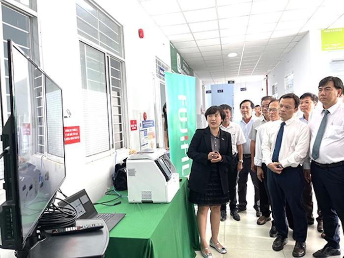 Lãnh đạo Sở Y tế cùng các đại biểu tham quan hoạt động vận hành và chạy mẫu thực tế trên thiết bị xét nghiệm sinh hóa khô. Ảnh: Sở Y tế Cần Thơ.