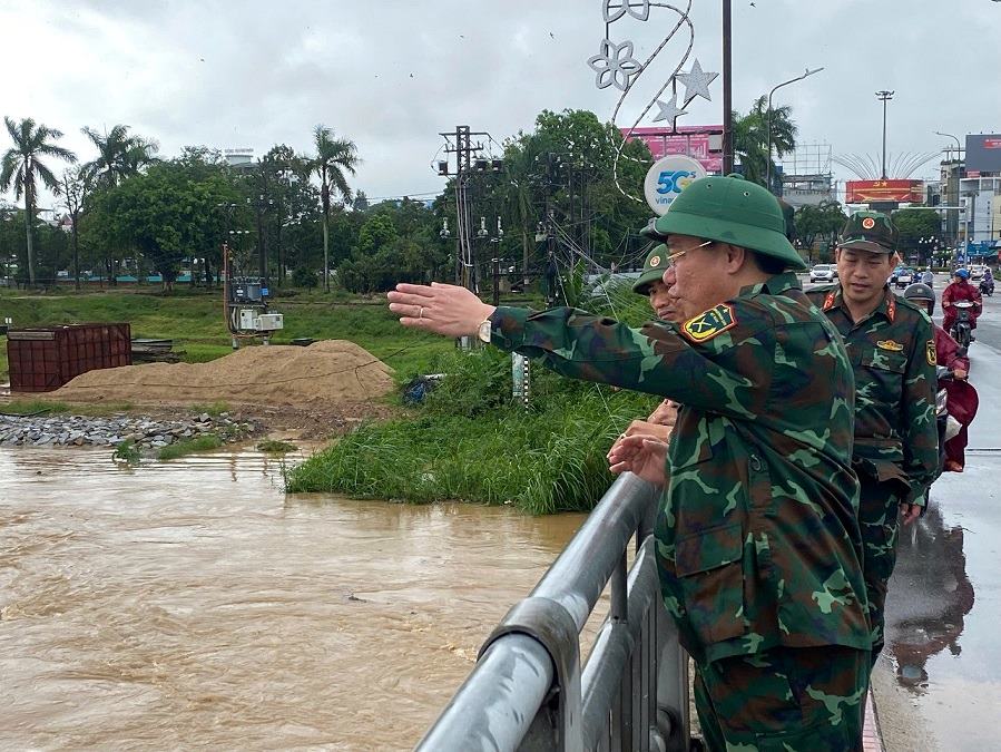 Thượng tá Trần Thế Phan, Uỷ viên Ban thường vụ Tỉnh uỷ, Chỉ huy trưởng Bộ Chỉ huy quân sự tỉnh Quảng Ngãi kiểm tra thực tế mực nước lũ tại cầu Trà Khúc 1 vào sáng 29.10. Ảnh: Viên Nguyễn