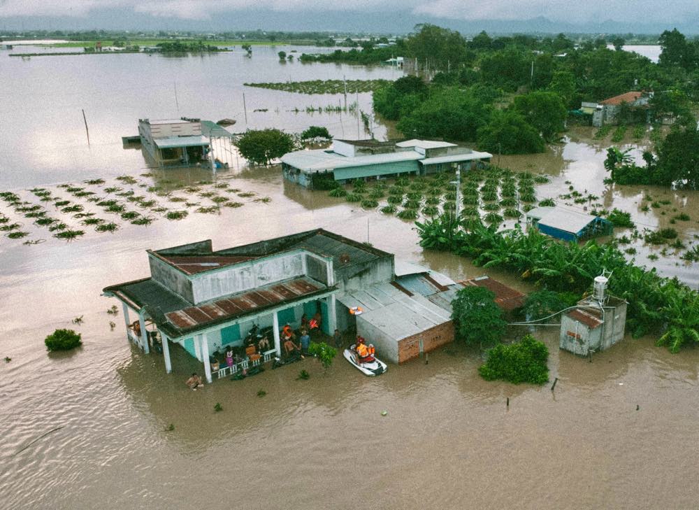 Dùng canô vào cứu hộ các nhà dân bị ngập. Ảnh: Duy Tuấn