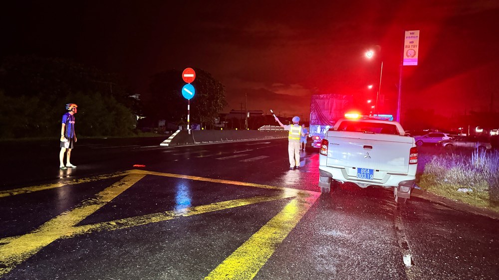 Cảnh sát Giao thông túc trực hướng dẫn các phương tiện đi đường khác do ngập trên Quốc lộ 1. Ảnh: Duy Tuấn