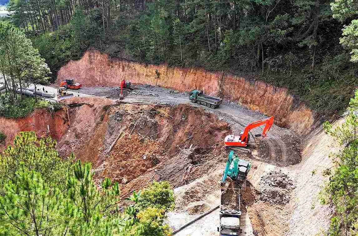 Đơn vị thi công đang huy động tổng lực người và phương tiện tập trung hoàn thành việc mở đường tạm qua điểm sạt lở trên đèo Mimosa. Ảnh: Thần Hy