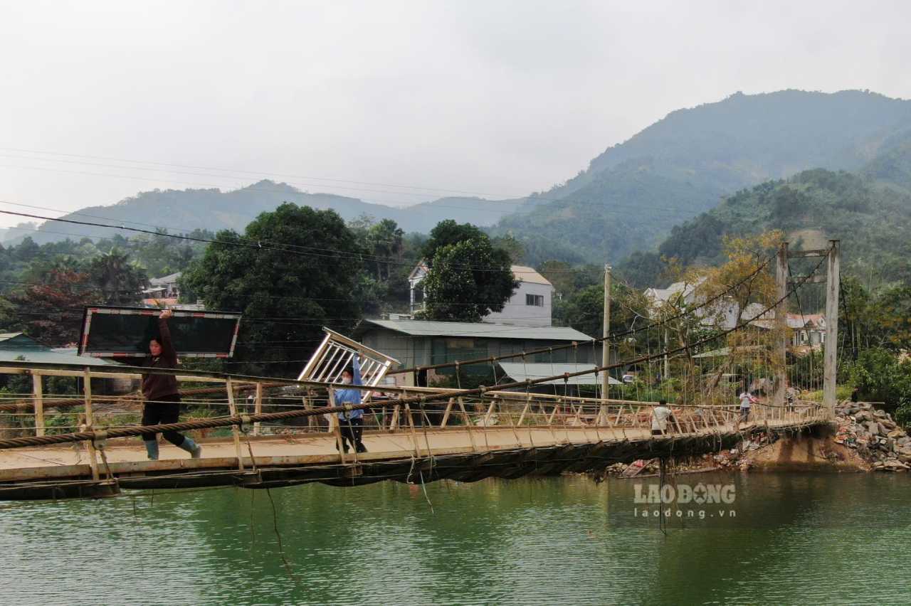 Người dân phải liều minh vận chuyển vật liệu qua cầu để sửa chữa nhà cửa. Ảnh: Văn Đức