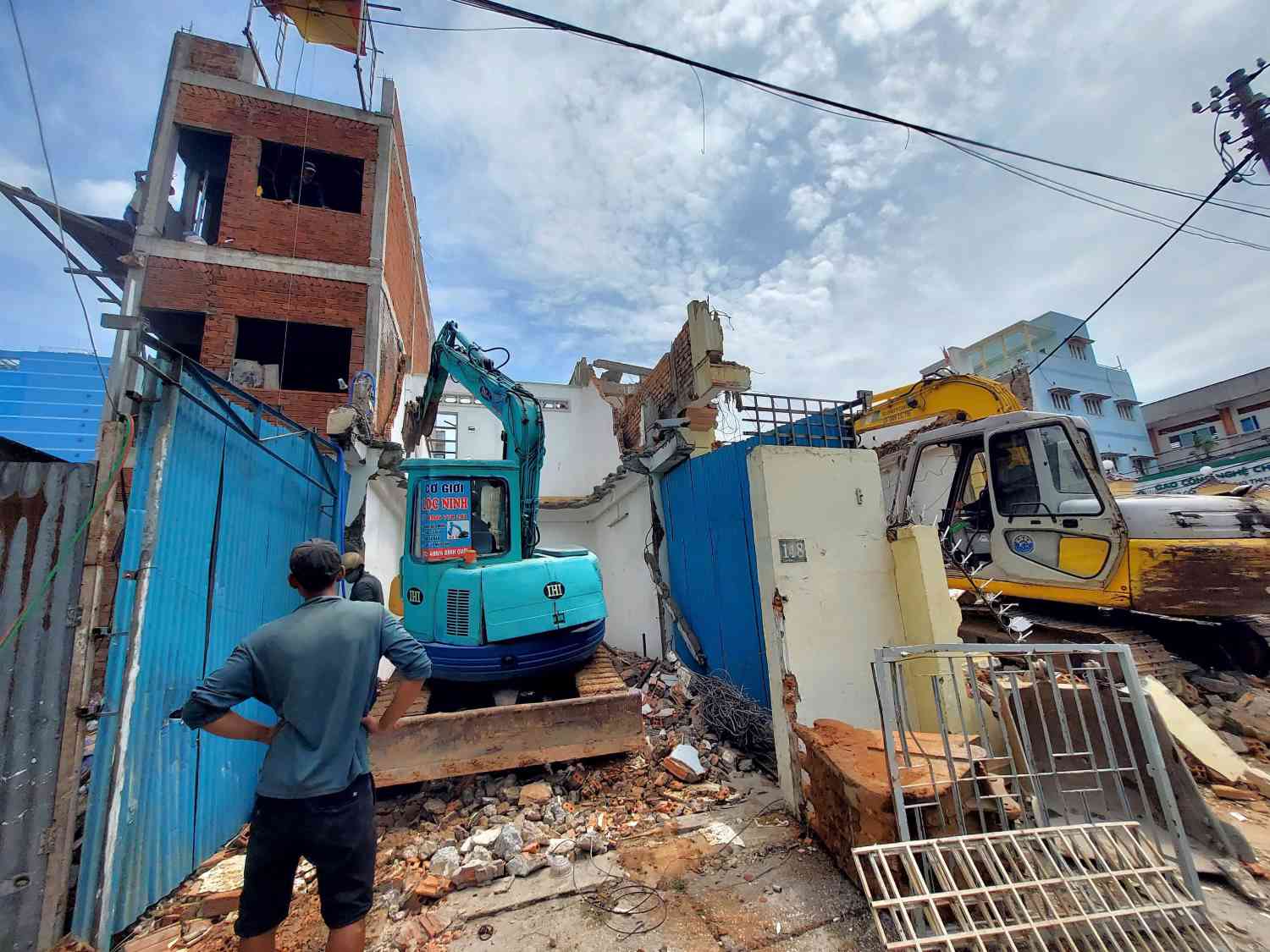 Người dân phá dỡ nhà để bàn giao mặt bằng làm cầu đường Nguyễn Khoái.  Ảnh: Minh Quân