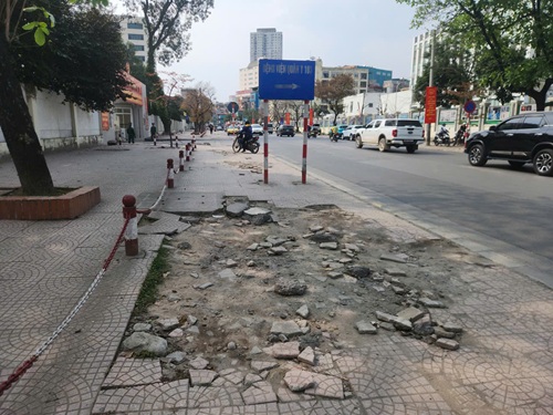 Vỉa hè đường 70 bong tróc, lồi lõm suốt gần một năm chưa sửa. Ảnh: Minh Hạnh