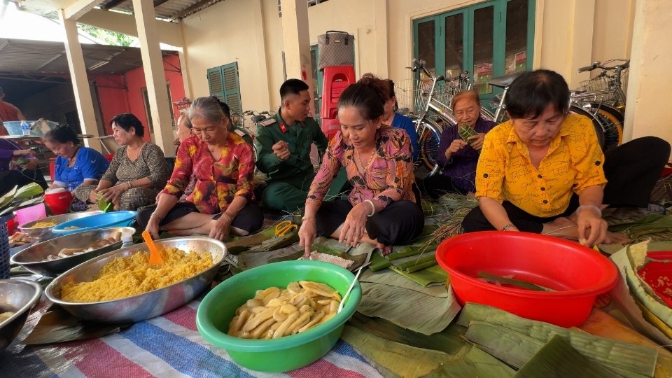 Người dân xã Trà Côn quây quần bên nhau tham gia gói bánh tét Tết Quân dân. Ảnh: Hoàng Lộc