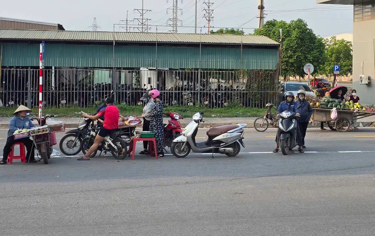 Người dân vô tư bán hàng dưới lòng đường ĐT. Ảnh: Diệu Anh