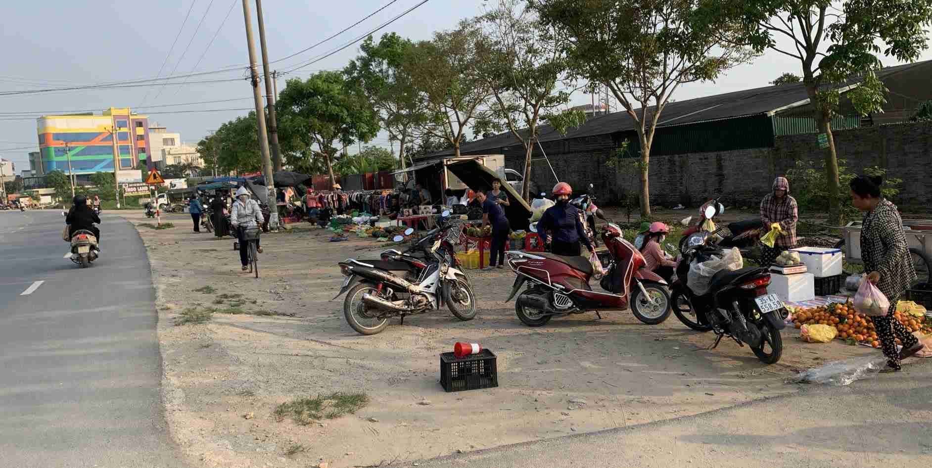 Người dân lập chợ “cóc” bán hàng ngay trước cổng Công ty TNHH sản xuất  giày Chung Jyu (Cụm công nghiệp Khánh Nhạc). Ảnh: Diệu Anh