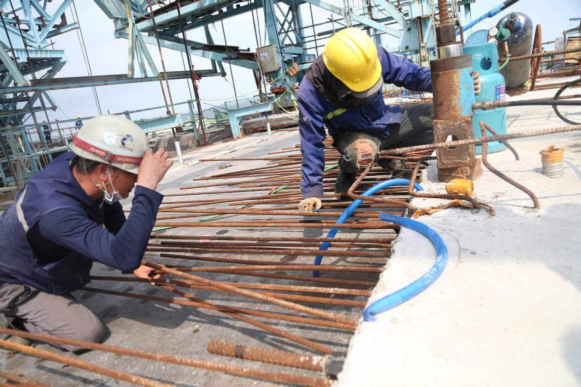 Hàng chục kỹ sư, công nhân bám trụ trên độ cao hàng chục mét, miệt mài thi công dưới thời tiết nắng nóng.