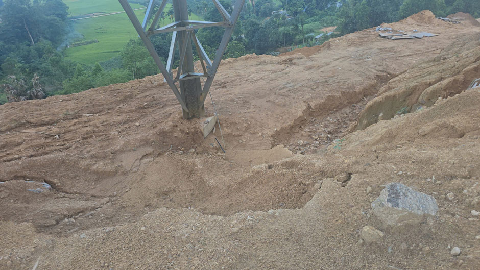 Mảng taluy bị khoét sâu, đất đá trôi tụ quanh chân móng cột 305. Ảnh: Nguyên Phong