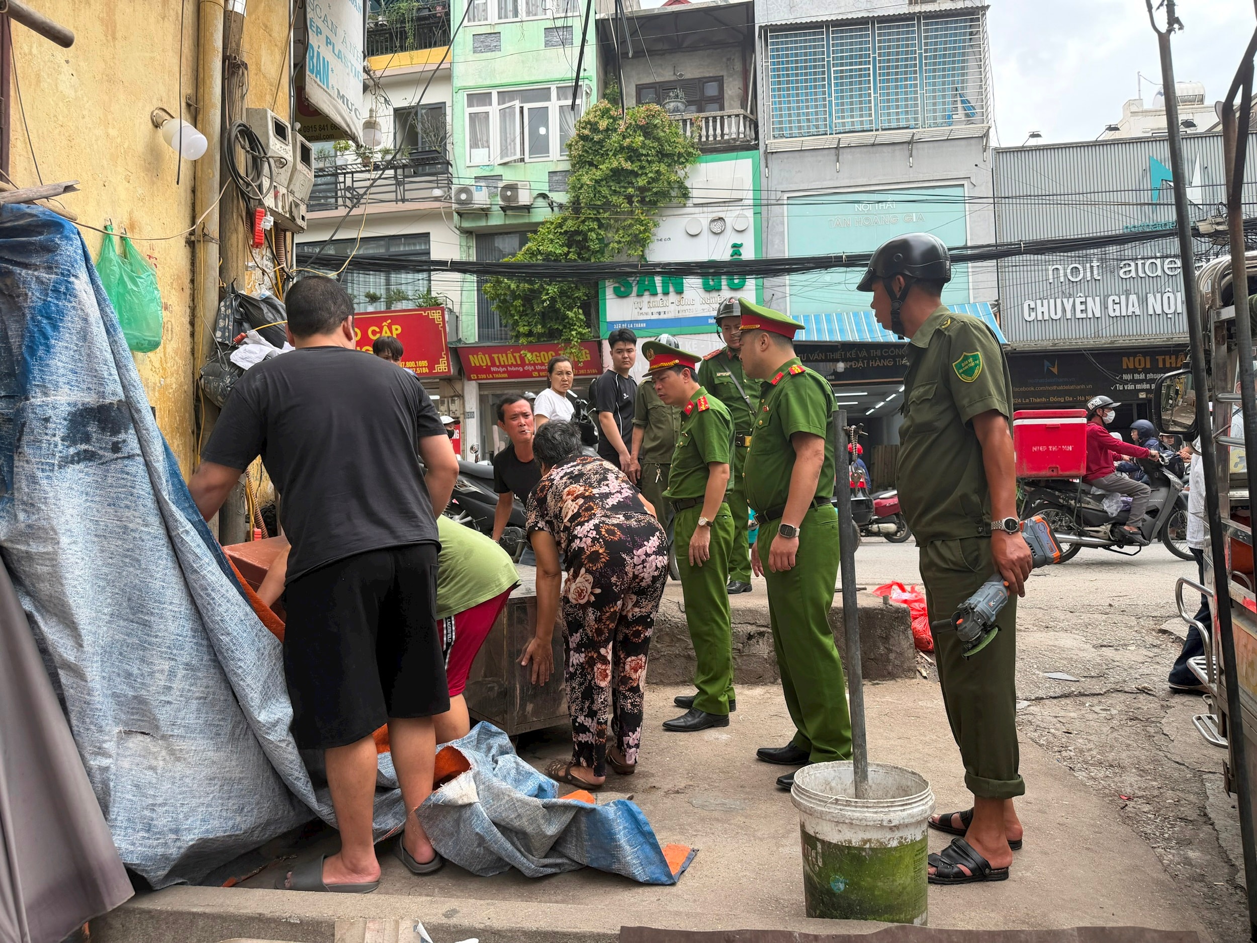 Các hộ dân được cán bộ Công an hướng dẫn, nhắc nhở thực hiện vệ sinh môi trường và trật tự đô thị, đồng thời tuyên truyền nâng cao ý thức cộng đồng. Ảnh: Võ Giang