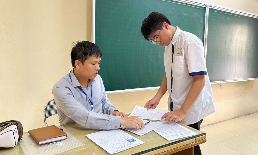 Giám thị hướng dẫn thí sinh kiểm tra thông tin cá nhân tại điểm thi Trường Trung học phổ thông Ngô Sĩ Liên (phường Bắc Giang). Ảnh: Thanh Tú/ BNO giam-thi-huong-dan-thi-sinh.jpg