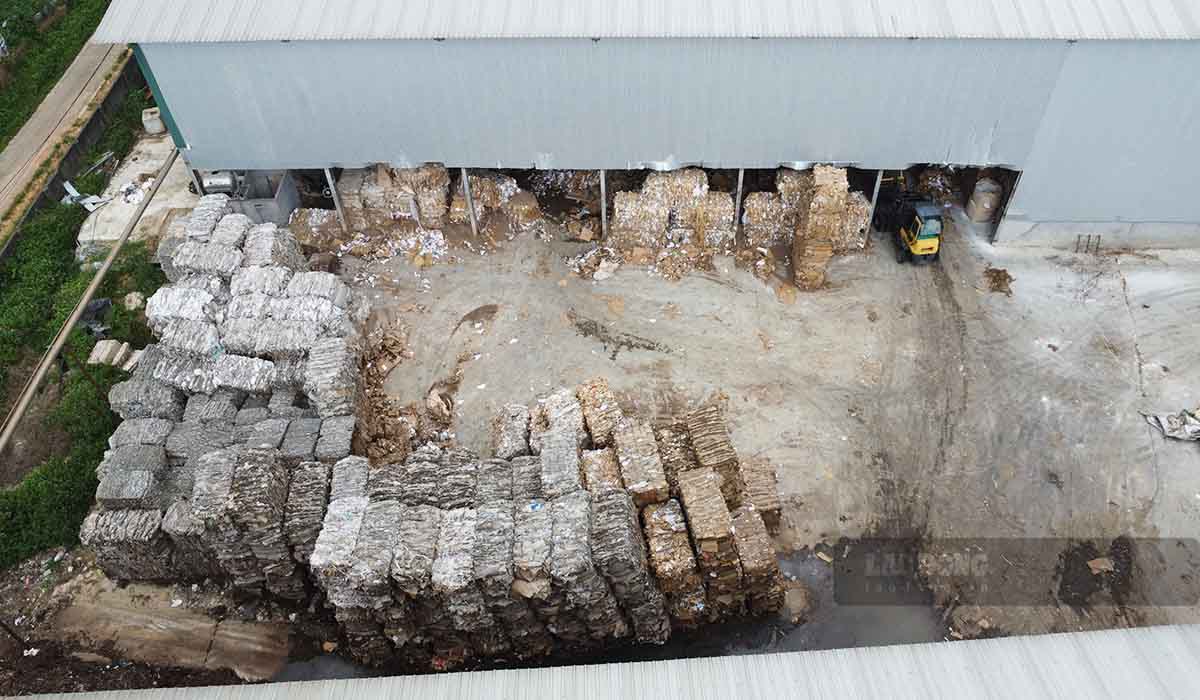 Giấy phế liệu chất đầy từ ngoài sân tới bên trong nhà xưởng. Ảnh: PV.