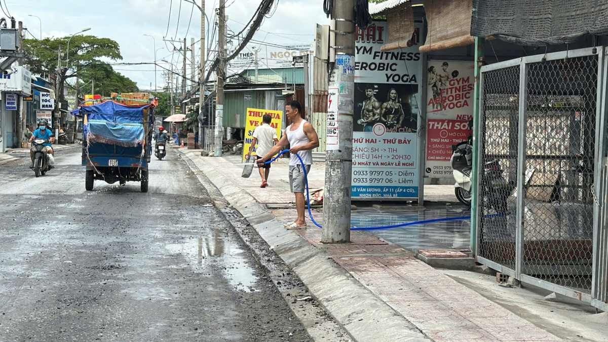 Một số đoạn đang sửa chữa, nhiều bụi nên người dân phải xịt nước liên tục. Ảnh: Minh Tâm