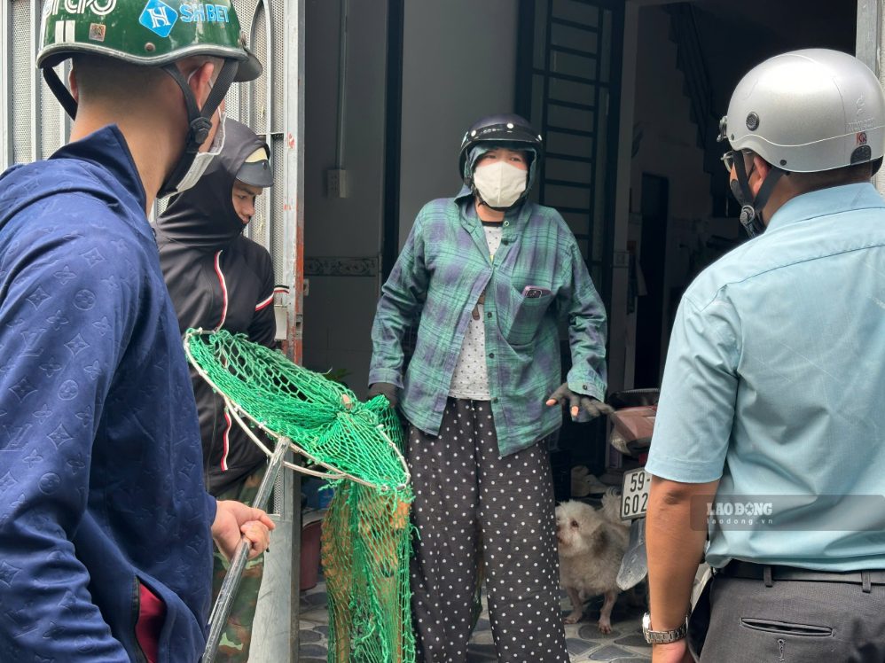 Chủ vật nuôi xin lại chó sau khi bị lực lượng chức năng vây bắt. Ảnh: Minh Tâm