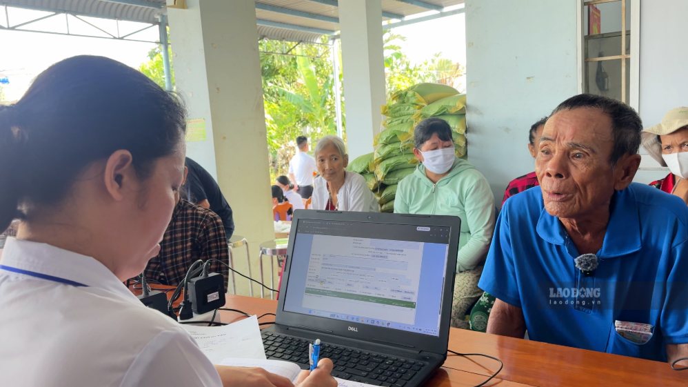 Nhân viên y tế hỗ trợ người dân cập nhật thông tin trên Sổ sức khỏe điện tử. Ảnh: Vĩnh Long