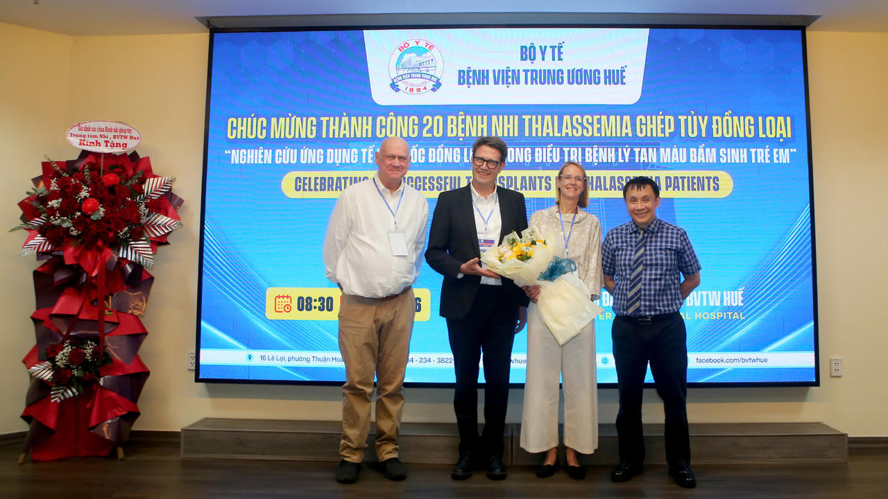GS.TS Phạm Như Hiệp, Giám đốc BVTW Huế tặng hoa cảm ơn các chuyên gia của Tổ chức DKMS trong ghép tủy cho các bệnh nhi. (Ảnh: B. Trâm)