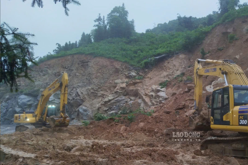 Máy móc được huy động hót dọn đất đá, thông đường sau sạt lở. Ảnh: Đinh Đại