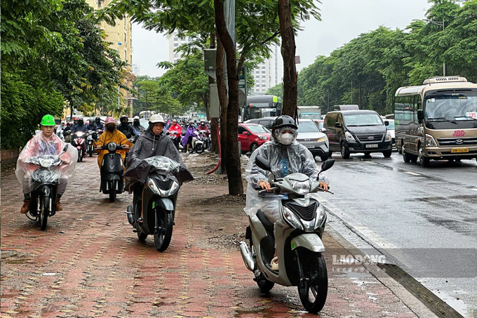 Nhiều người dân đi lên vỉa hè để tránh điểm ùn tắc. Ảnh: Tô Thế