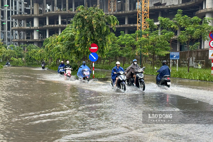 Khoảng 7h45, tại lối vào Khu đô thị Ciputra xuất hiện biển cảnh báo ngập sâu. Người dân di chuyển khó khăn, một số phương tiện bị chết máy. Ảnh: Hạnh Thơm